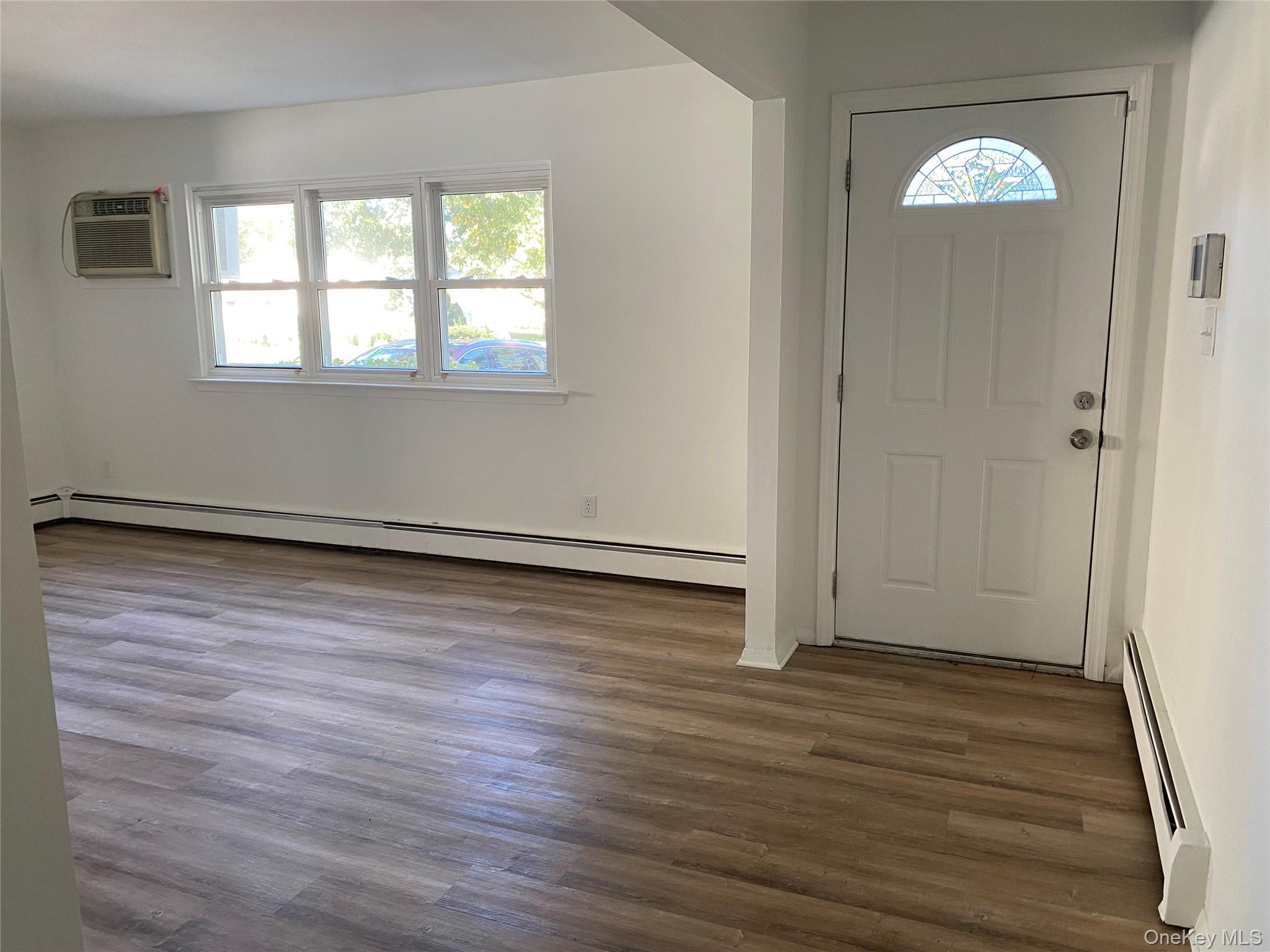 7 Filmore Avenue Coram, NY 11727 - Photo 6 of 22 an empty room with wooden floor and windows