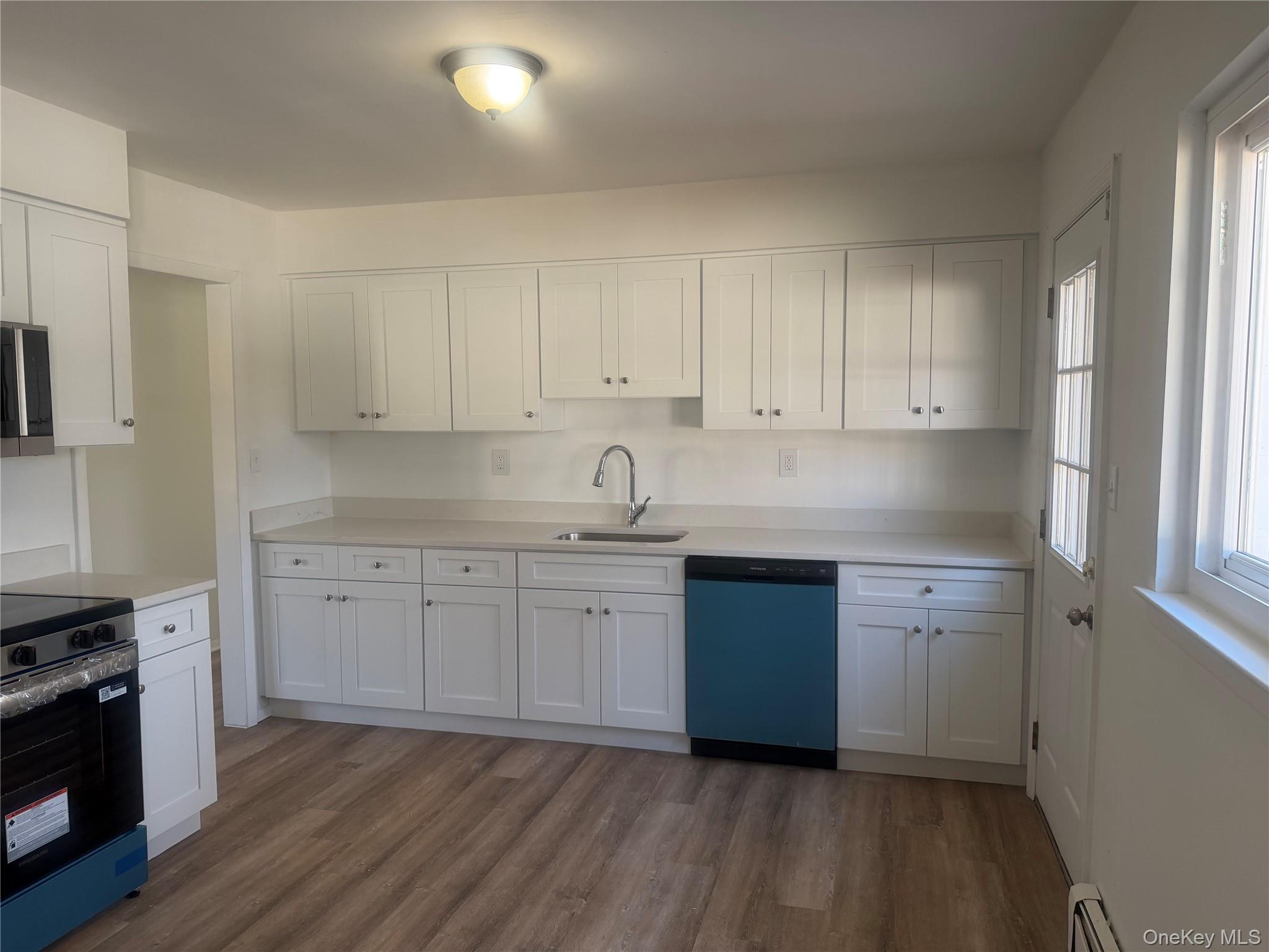 7 Filmore Avenue Coram, NY 11727 - Photo 7 of 22 a kitchen with granite countertop white cabinets and white appliances