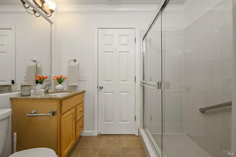 a bathroom with a granite countertop sink mirror vanity and toilet