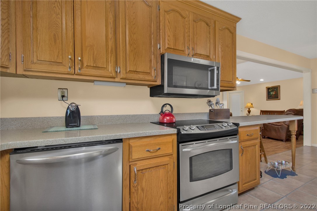 1197 Rowan Road Lumberton, NC 28358 - Photo 16 of 37 a kitchen with granite countertop a stove top oven microwave and cabinets