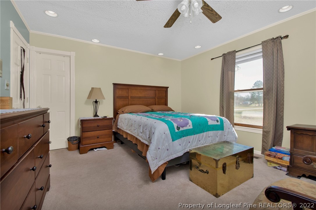 1197 Rowan Road Lumberton, NC 28358 - Photo 24 of 37 a bedroom with a bed and a chandelier
