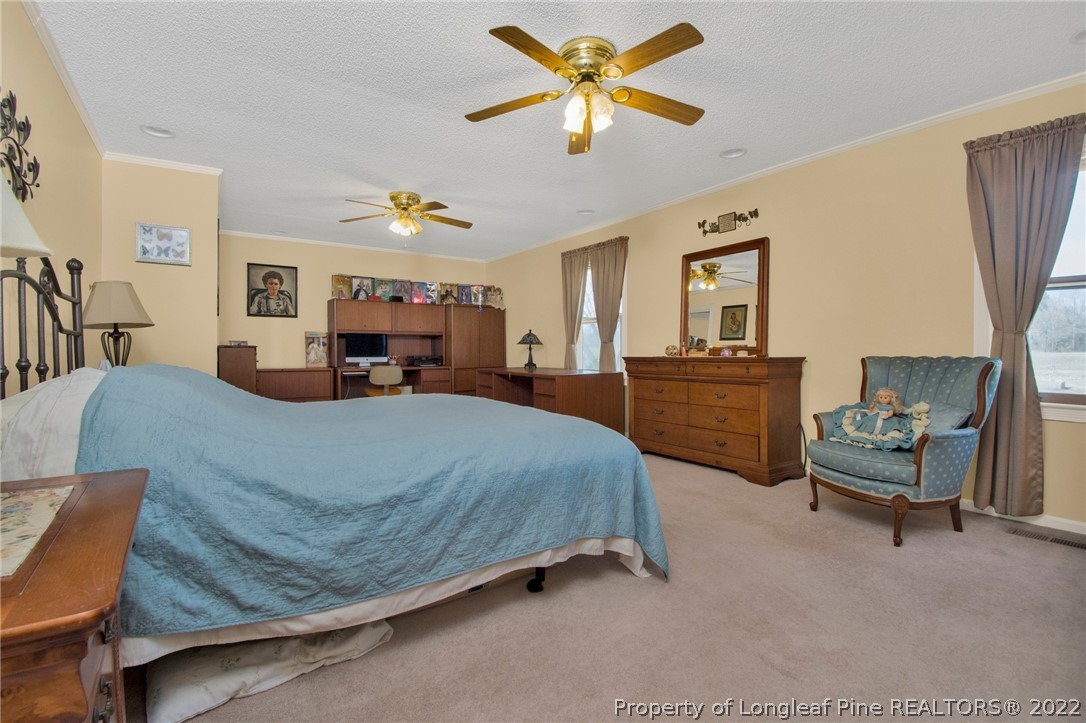 1197 Rowan Road Lumberton, NC 28358 - Photo 26 of 37 a bed room with a bed and a chandelier