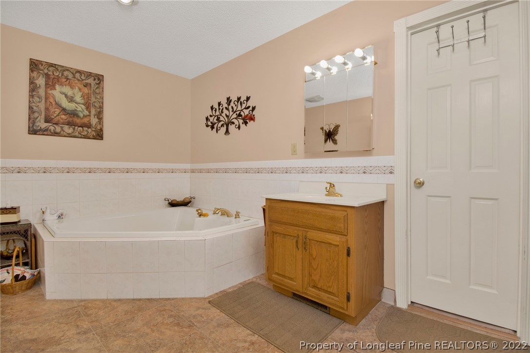 1197 Rowan Road Lumberton, NC 28358 - Photo 29 of 37 a spacious bathroom with a tub a sink and mirror
