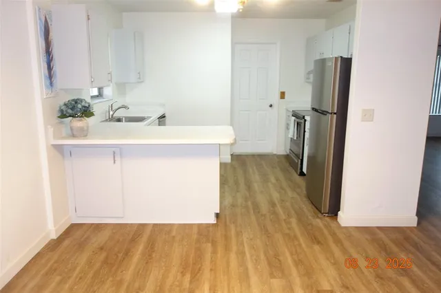 a view of a kitchen with a sink and refrigerator