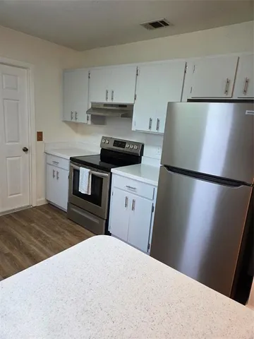 a kitchen with white cabinets and stainless steel appliances