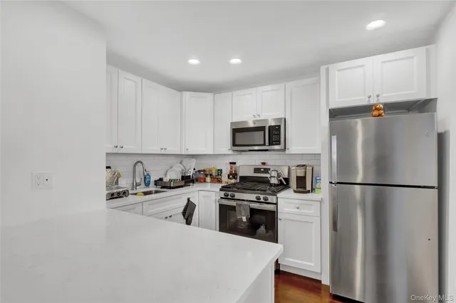 a kitchen with white cabinets and appliances