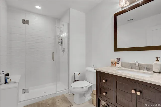a bathroom with a granite countertop sink toilet and shower