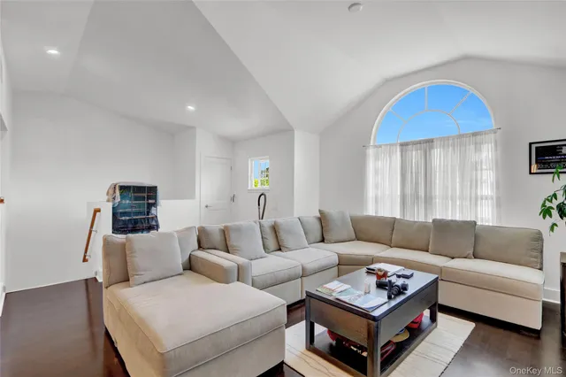 a living room with furniture a window and a wooden floor
