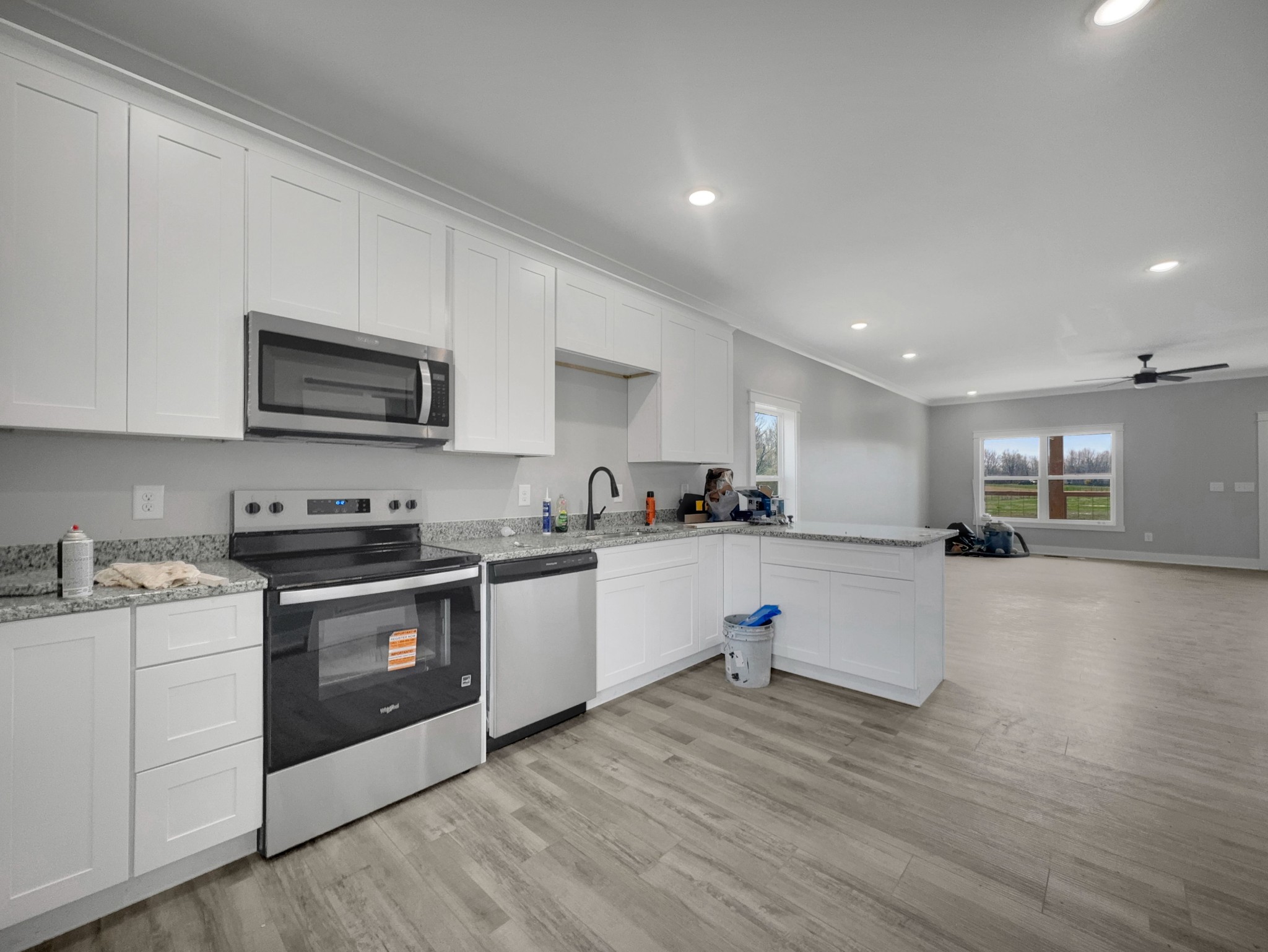 181 Rock House Hollow Road Bethpage, TN 37022 - Photo 18 of 50 a kitchen with stainless steel appliances granite countertop a stove top oven a sink dishwasher and a microwave oven with wooden floor