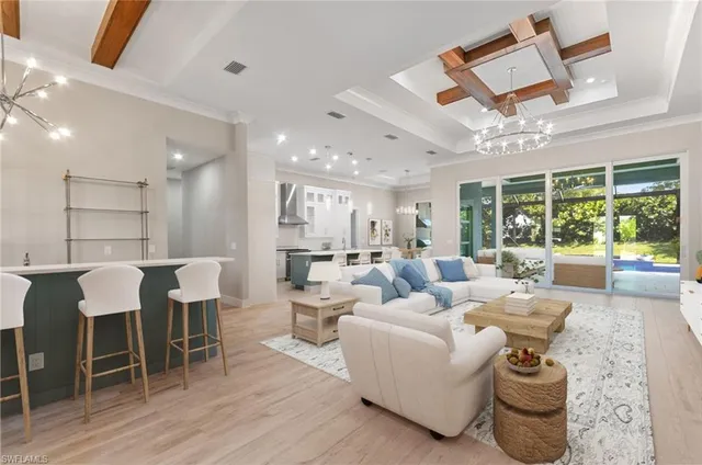 a living room with furniture kitchen view and a chandelier