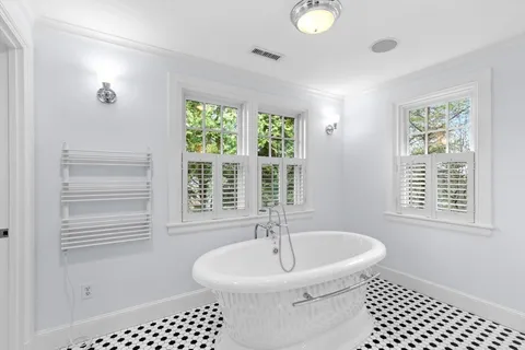 a spacious bathroom with a double vanity sink a large mirror and a bathtub
