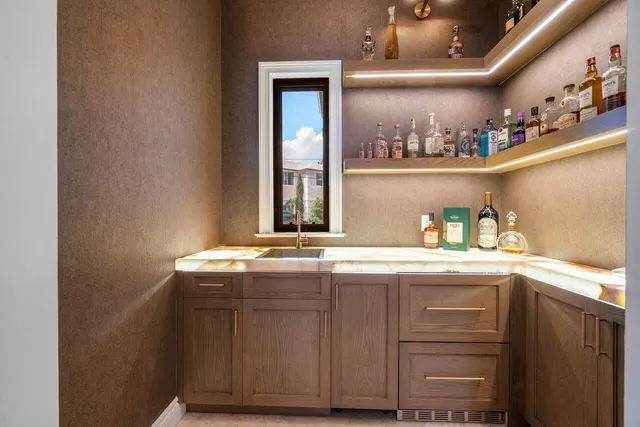 a spacious bathroom with a granite countertop double vanity sink a mirror and a bathtub