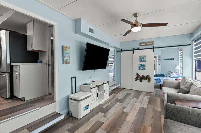 a view of a bedroom with wooden floor and balcony