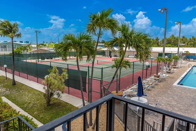 a view of a brick building with a red door and a chair