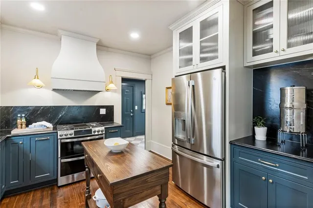 a kitchen with stainless steel appliances a refrigerator and a stove top oven