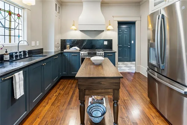 a kitchen with granite countertop stainless steel appliances a stove top oven and sink