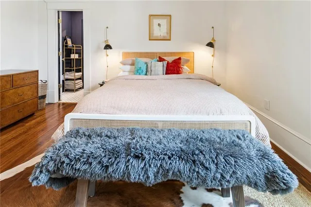 a bedroom with a bed and a flat tv screen on dresser