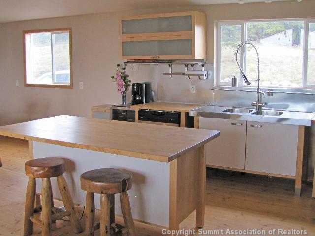 1723 Campfire Road Hartsel, CO 80449 - Photo 2 of 9 a kitchen with a table chairs sink and cabinets