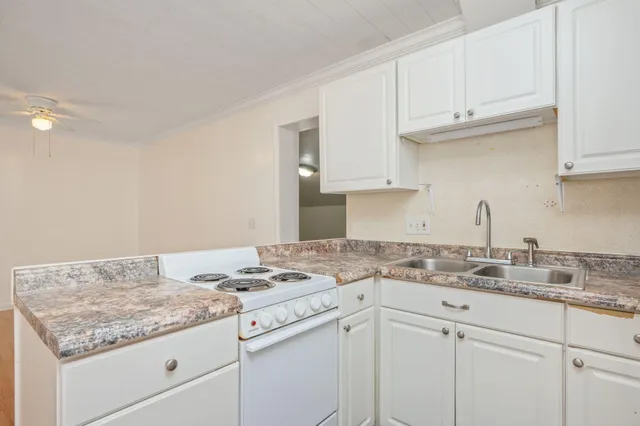 a kitchen with granite countertop white cabinets and a sink