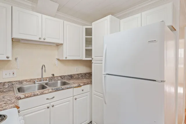 a kitchen with stainless steel appliances granite countertop white refrigerator stove and white cabinets