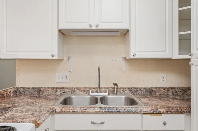 a kitchen with granite countertop a sink and cabinets