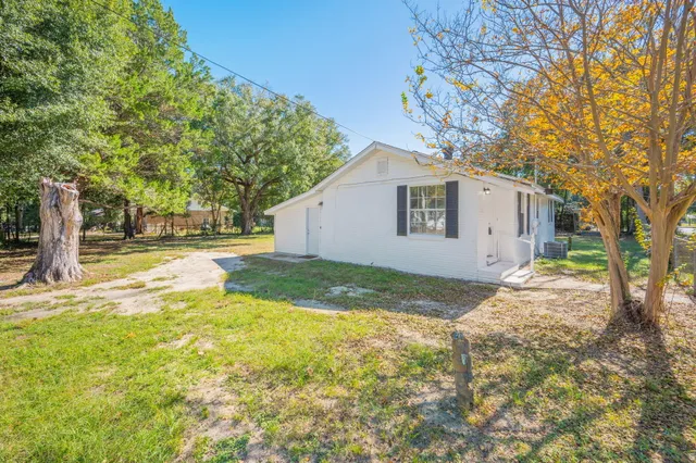 a view of a house with backyard and tree