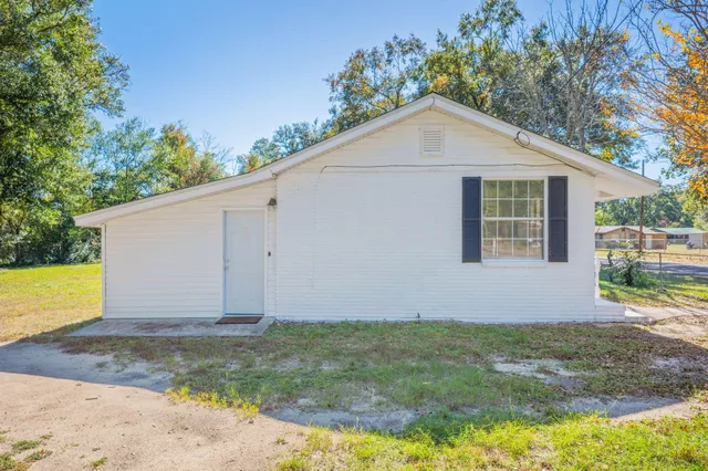 a view of a house with backyard and trees