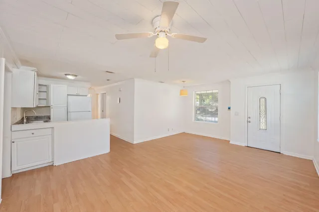 a view of an empty room with window and cabinet
