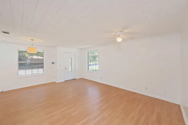 wooden floor in an empty room with a window