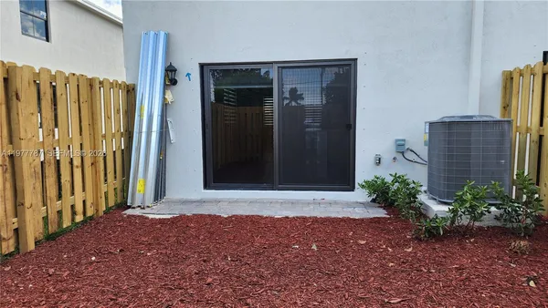 a view of a chairs and table in patio with a barbeque grill