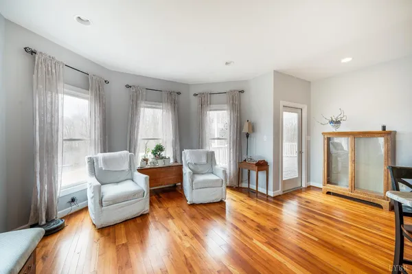 a spacious bedroom with a bed and a flat tv screen on dresser