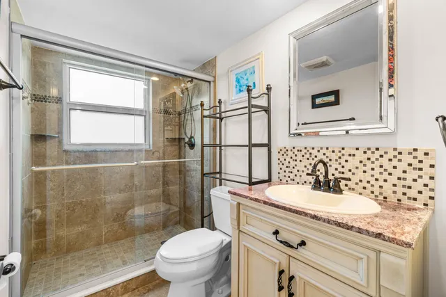 a bathroom with a sink a toilet and shower