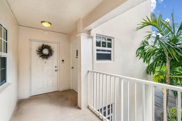 a view of a hallway to a window with wooden floor