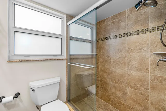 a bathroom with a toilet and a shower