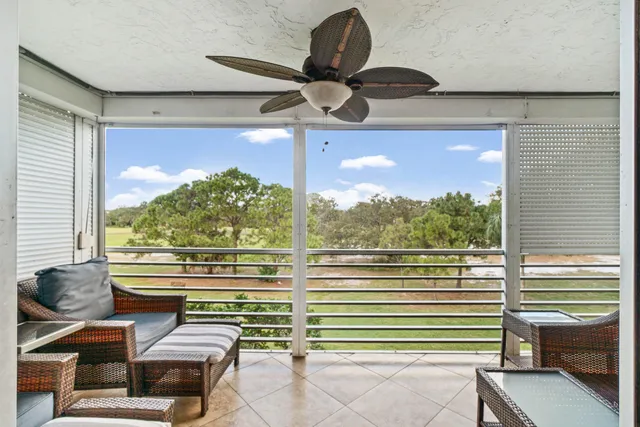 a view of a porch with furniture and a yard