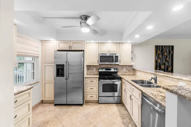 a kitchen with stainless steel appliances granite countertop a refrigerator and a stove top oven