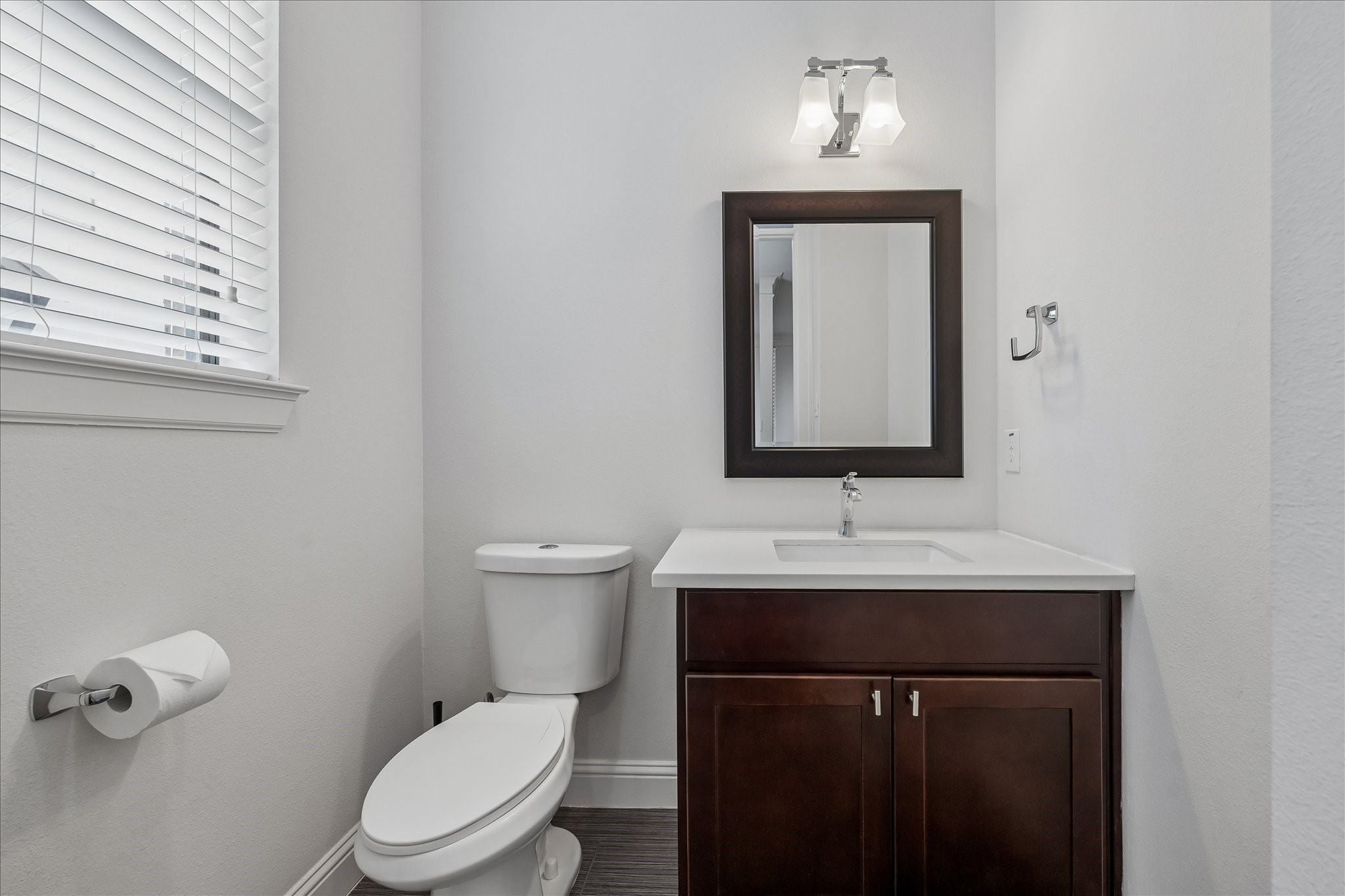 734 West 20th Street, Unit A Houston, TX 77008 - Photo 19 of 23 Second-floor powder room features modern lighting, a stylish mirror & a window for natural light, offering a clean, functional space ideal for guests.