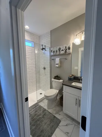 a bathroom with a granite countertop sink toilet and shower