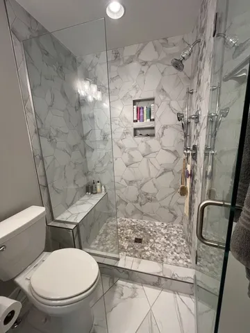 a bathroom with a toilet and a shower