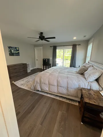 a bedroom with a bed a window and dresser