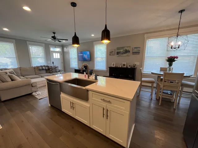 a view of a dining room and livingroom with furniture wooden floor a chandelier