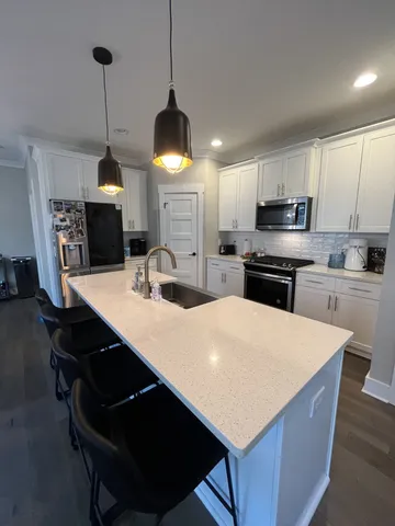 a kitchen with kitchen island a stove a sink a microwave a center island and a refrigerator