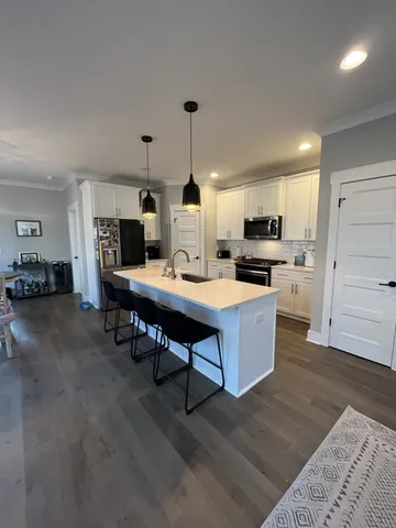 a open kitchen with stainless steel appliances kitchen island granite countertop a stove and a sink