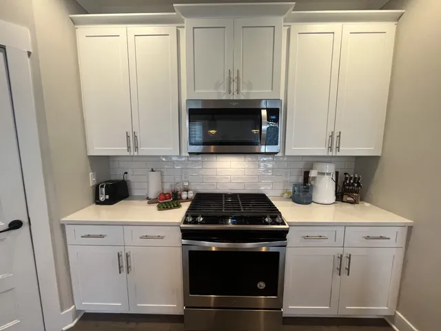 a kitchen with white cabinets and white appliances