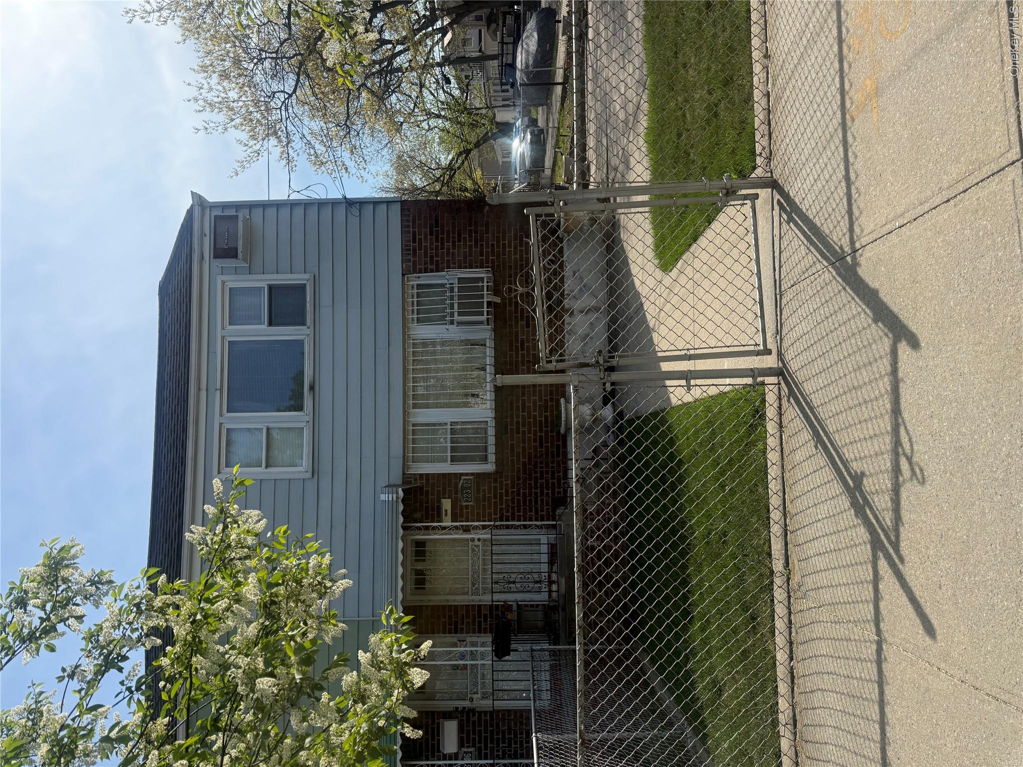 223-02 145th Road Queens, NY 11413 - Photo 2 of 6 a front view of a house with garden