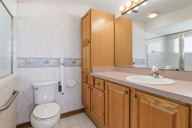 a bathroom with a granite countertop toilet sink and mirror