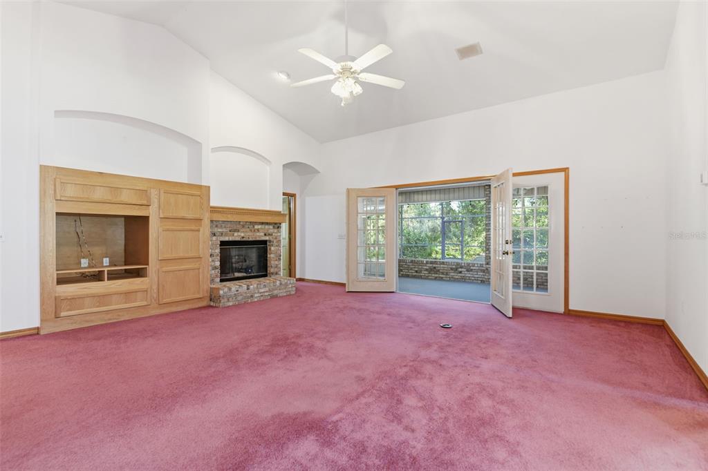 2409 South Spring Garden Avenue DeLand, FL 32720 - Photo 8 of 26 a view of an empty room with a fireplace and a large window