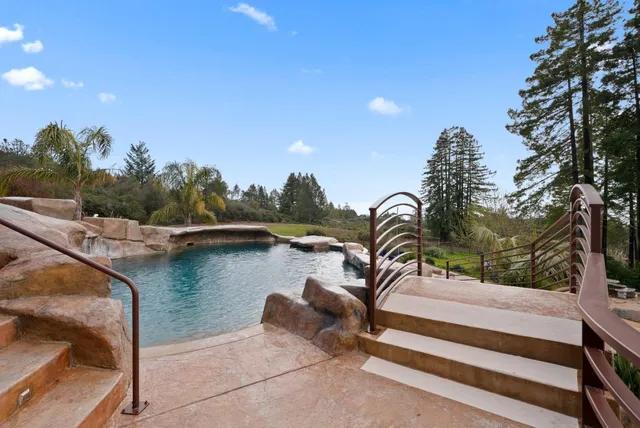 a living room with patio furniture and a garden