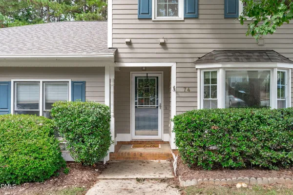 front view of a brick house with potted plants