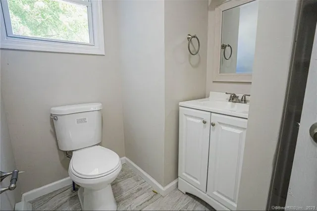 a bathroom with a toilet a sink and mirror